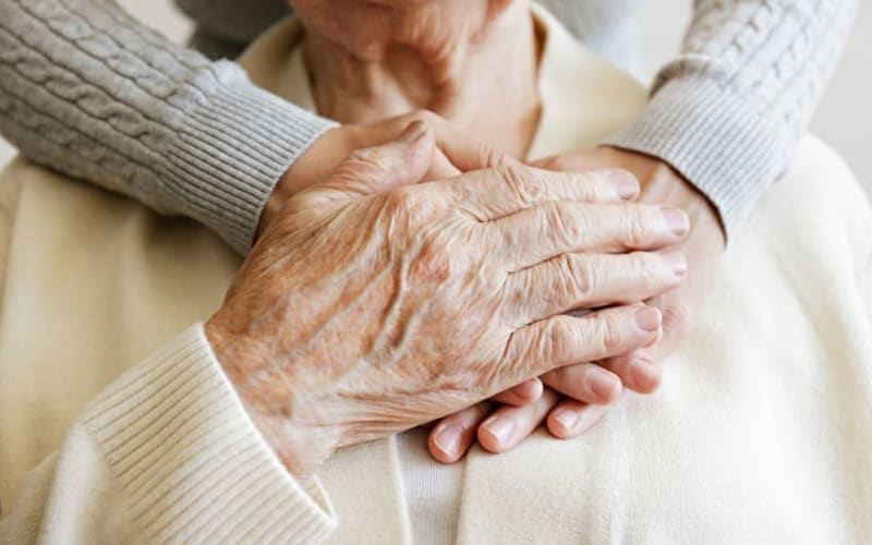 Resident embracing his daughter's hands at Grand Villa of DeLand in DeLand, Florida