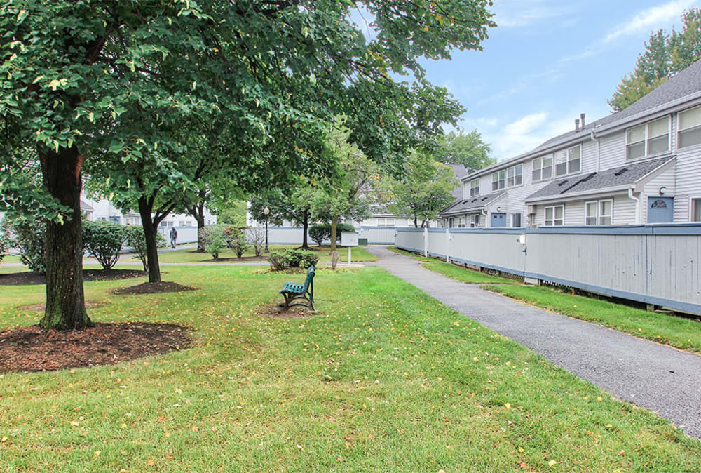 Walking path and park bench at Brighton Colony Townhomes in Rochester, New York