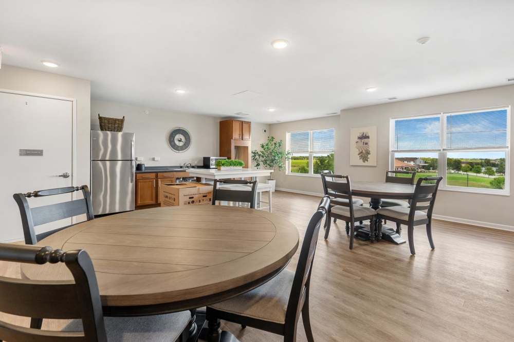 Community room with dining space and kitchen at Deville Manor in Oswego, Illinois