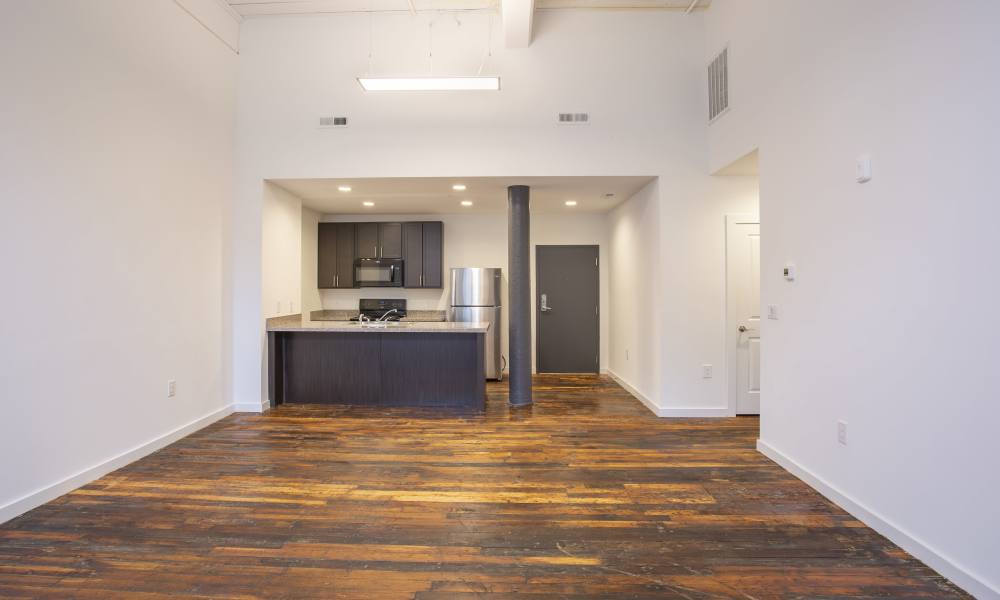 Wood-style floored living area with open kitchen at Lofts at Inman Mills in Inman, South Carolina