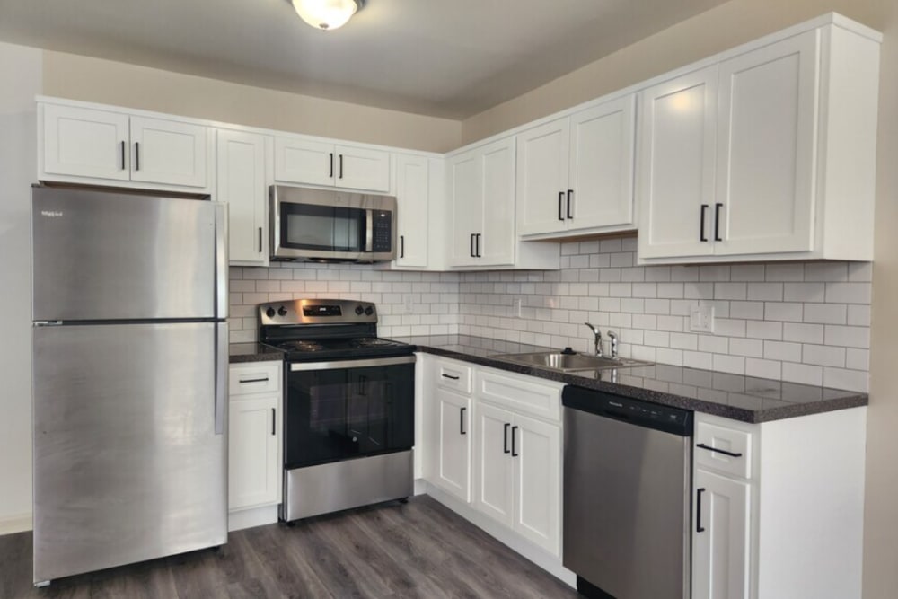 Model kitchen with white cabinetry and wood-style flooring at Blair Mill Village West in Horsham, Pennsylvania