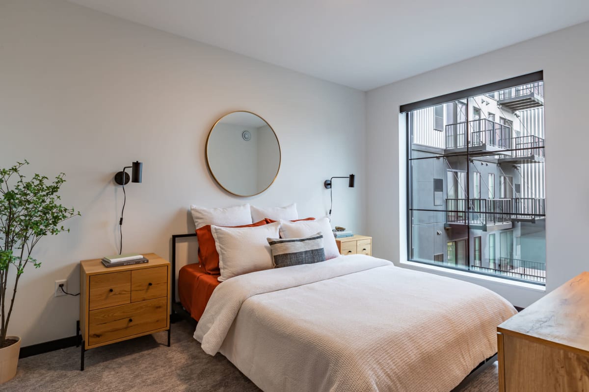 Apartment bedroom with a bright window at Carbon31 in Bloomington, Minnesota