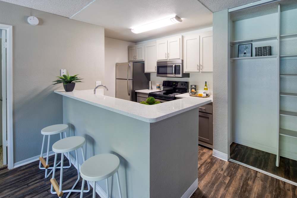 Kitchen with quartz countertop and barstool at Falls at Arden in Sacramento, California