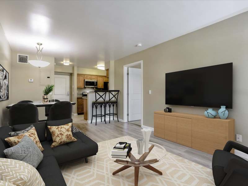 Modern apartment living room with large couch, chairs and wood-style flooring at Santa Teresa Apartments in San Jose, California