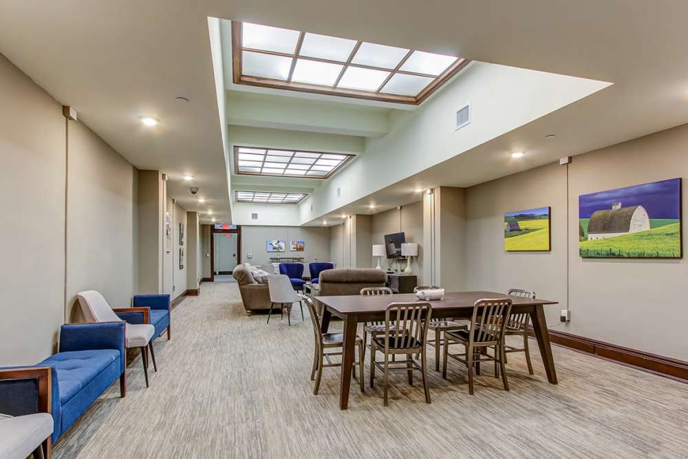 Bright community lounge with a dining table for gatherings at 43 Town Square in Lima, Ohio