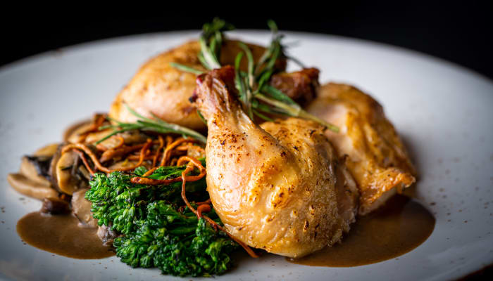Roasted chicken and greens on a dish at The Springs at Lancaster Village in Salem, Oregon