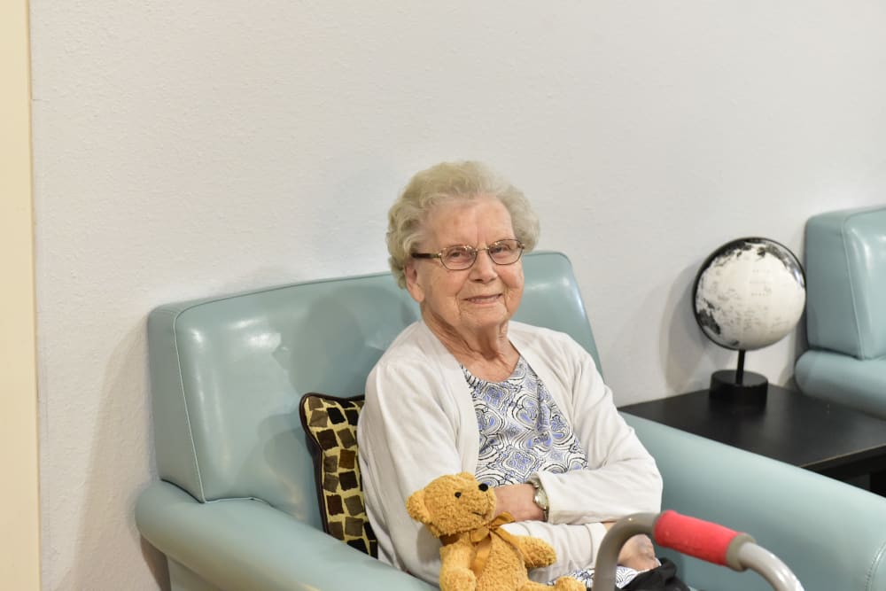 Resident relaxing and holding a stuffed animal at Reflections at Garden Place in Columbia, Illinois. 