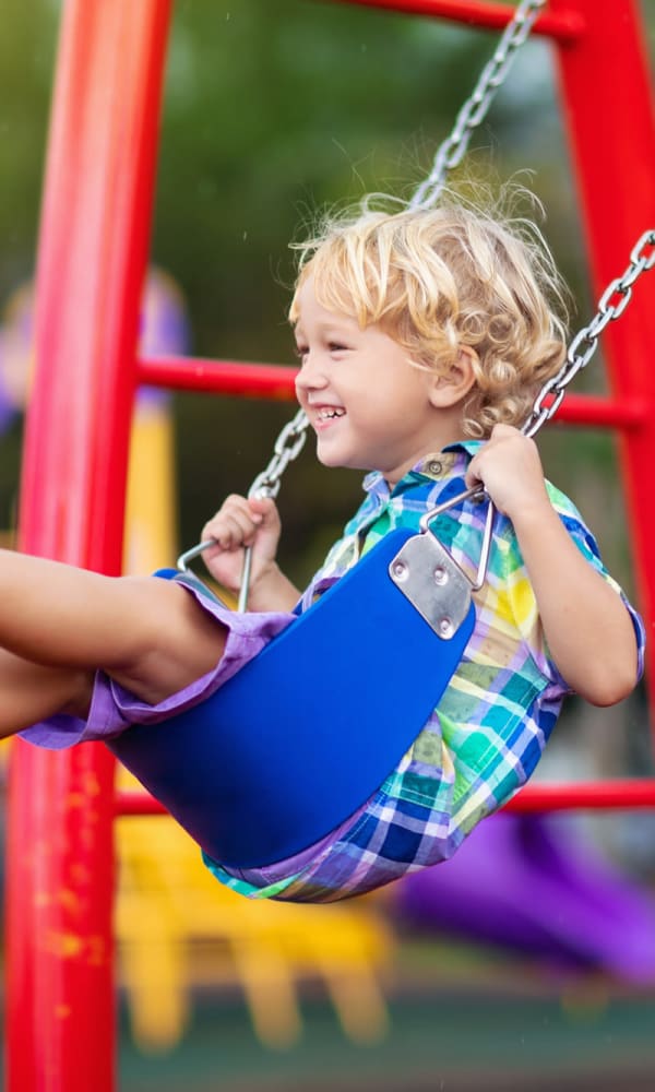 Children swing in playground near  The Abbey At Enclave in Houston, Texas