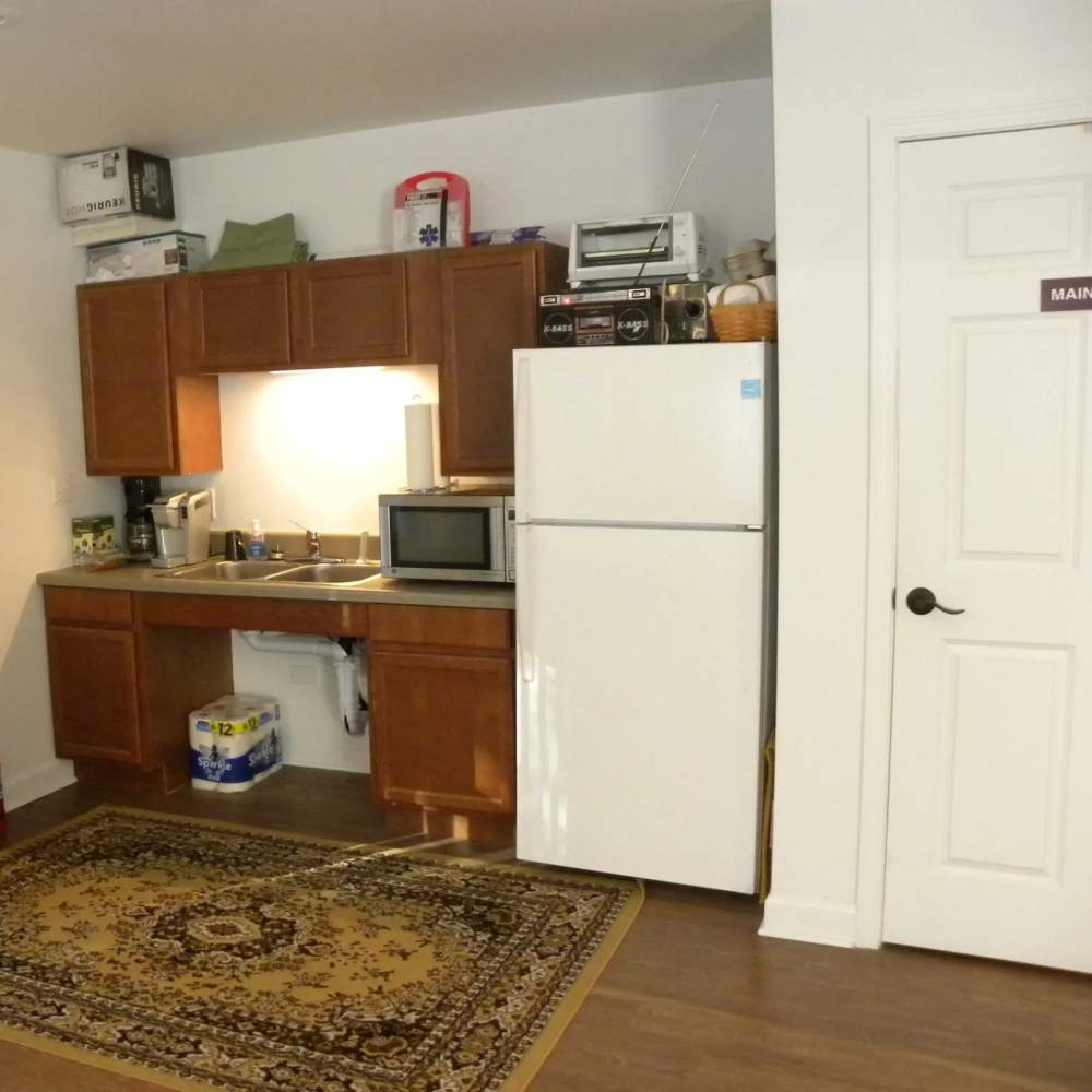 Modern kitchen with wooden cabinetry and refrigerator at Copper Hills Apartments in Houghton, Michigan