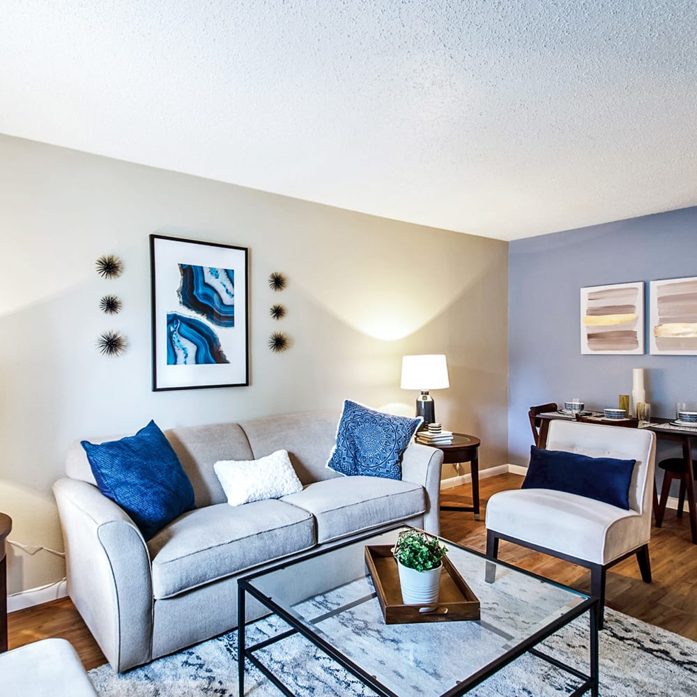 Spacious living room with tv, fireplace, and a ceiling fan at Broadmoor Ridge Apartment Homes in Colorado Springs, Colorado