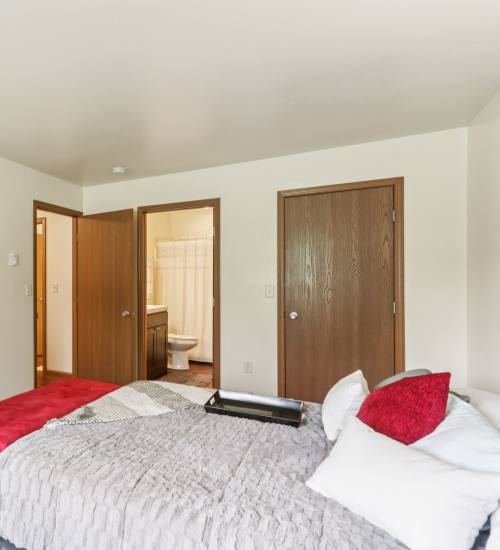Bedroom with comfortable bed at Woodfield Heights Apartments in Waukesha,Wisconsin