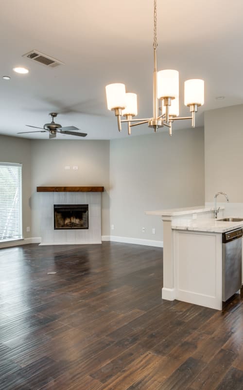 Living room with fireplace and hanging light fixture at The Collection Townhomes in Dallas, Texas