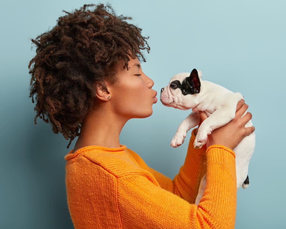 Resident kissing her puppy at Cedar Park & Canyon Falls Townhomes in Twin Falls, Idaho