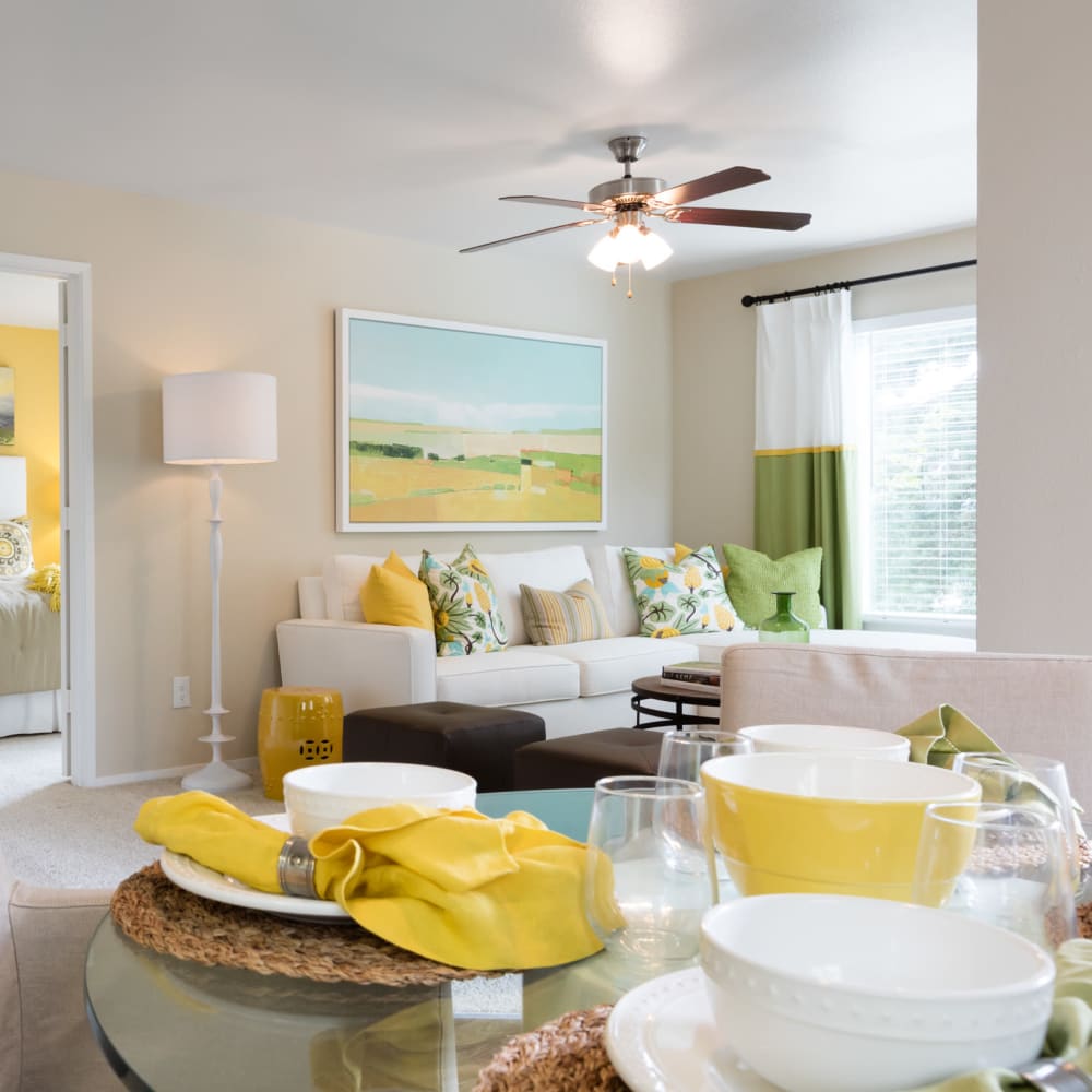 Open-concept living and dining areas with a ceiling fan and plush carpeting in a model home at Skyline at Murrayhill in Beaverton, Oregon