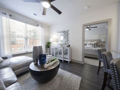 Living room of a model home with hardwood-style floors and courtyard views at Steelyard in Oklahoma City, Oklahoma