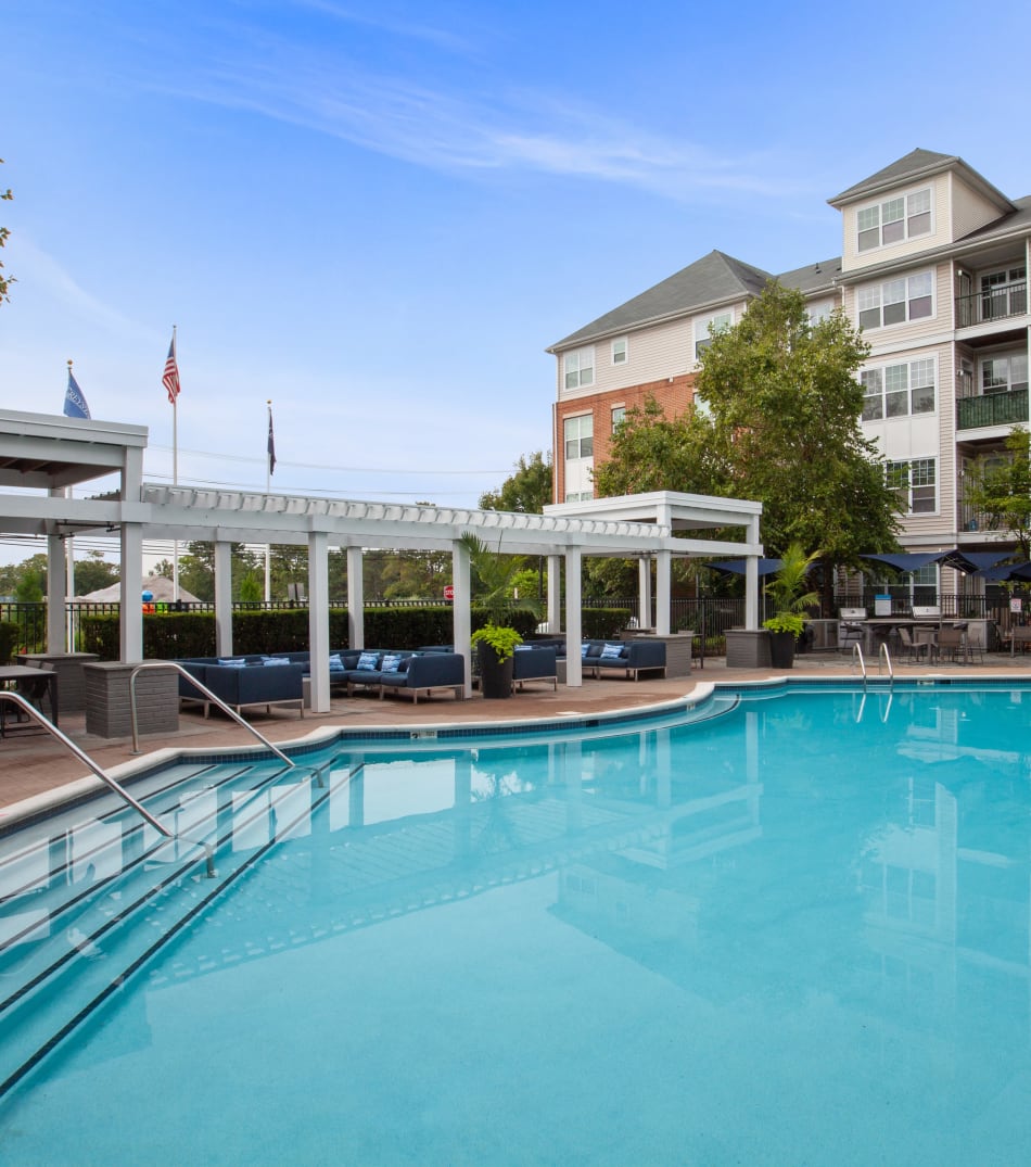 Refreshing swimming pool with lounge chairs on the side to relax in after a swim at Sofi Lyndhurst in Lyndhurst, New Jersey