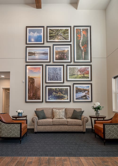 Welcoming lobby with multiple couches and framed photos on the wall at The Pillars of Grand Rapids in Grand Rapids, Minnesota