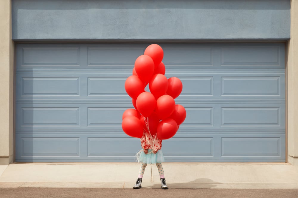 A child holding a bunch of balloons at BB Living at Civic Square in Goodyear, Arizona