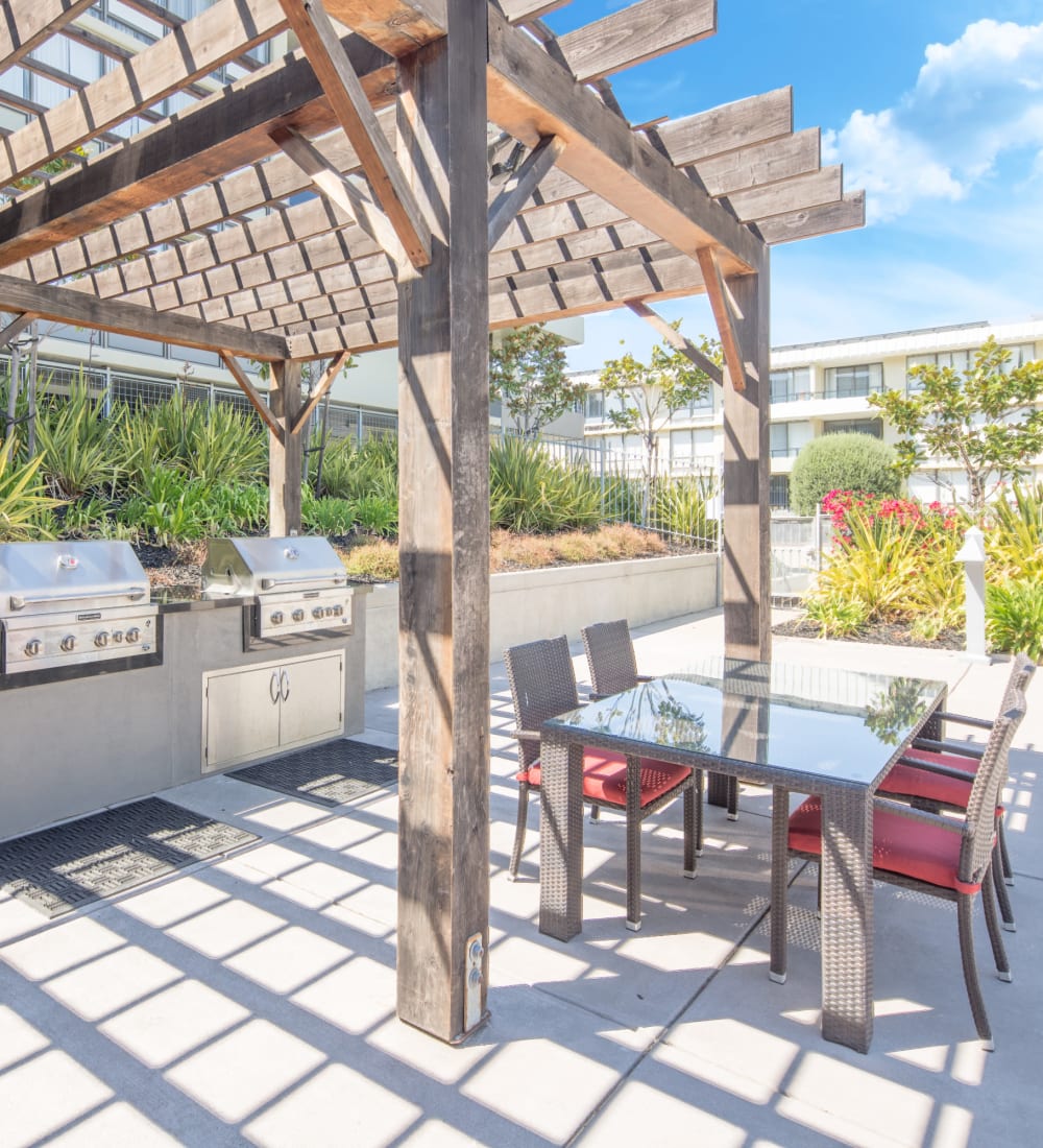 Relaxing outdoor common area with BBQ grills at Skyline Terrace Apartments in Burlingame, California