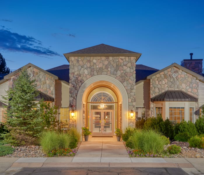 Exterior clubhouse view with beautiful landscaping at sunrise at Legend Oaks Apartments in Aurora