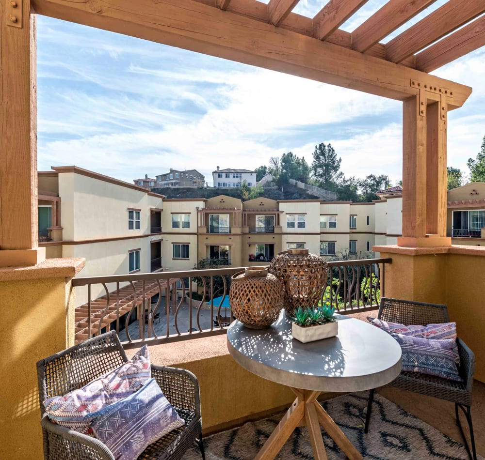 Large private balcony with a pergola above outside an apartment home at Sofi at Topanga Canyon in Chatsworth, California