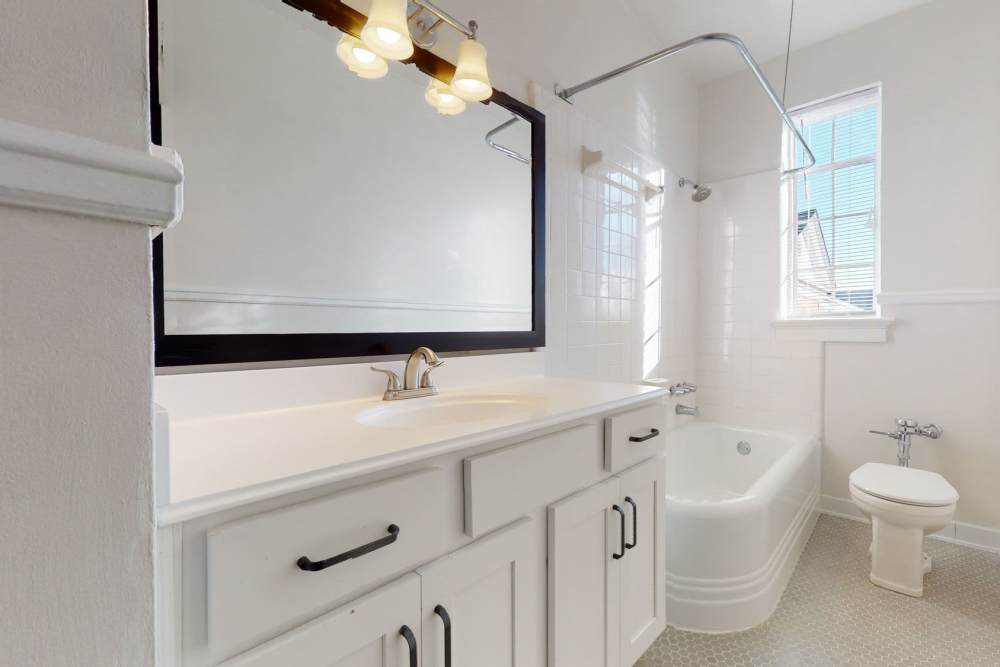 Bright bathroom with large mirror and storage space at Historic Boylan Apartments in Raleigh, North Carolina