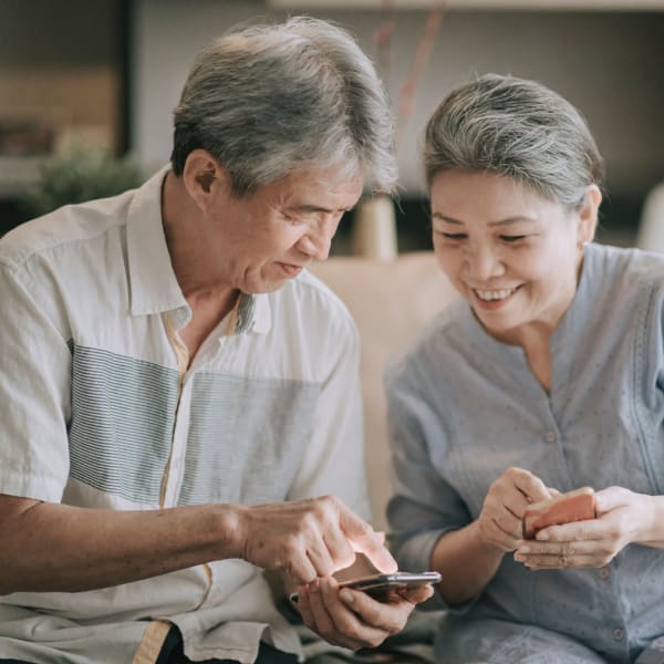 A couple looking at their phones at Alta Vista Senior Living in Vista, California