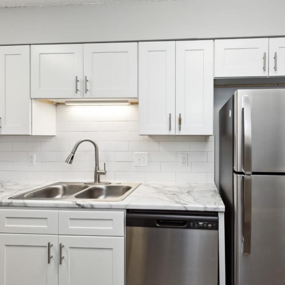 Kitchen with a stainless-steel sink, refrigerator and wooden cabinetry at Meadow Glen Apartments in Springfield, Tennessee