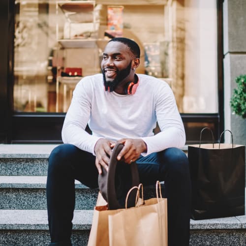 a man sitting with his shopping bags on a stoop at The Linq in Chandler, Arizona