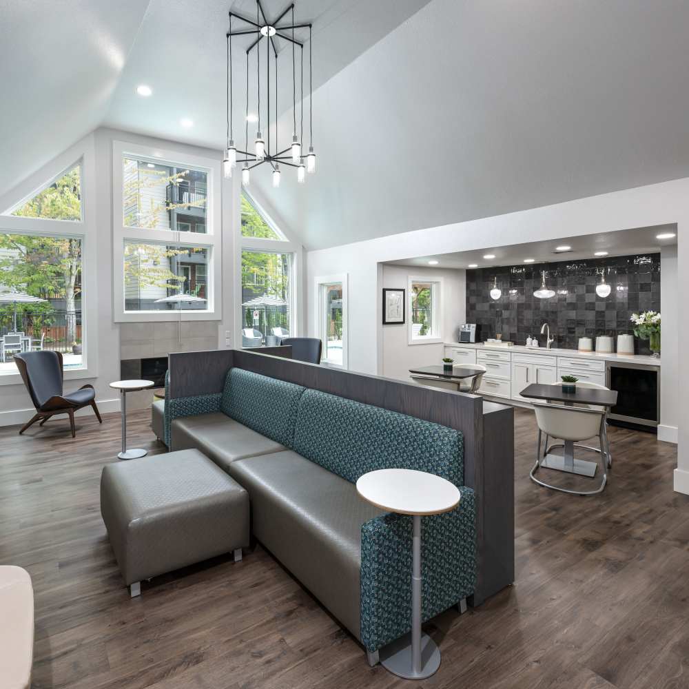 Community clubhouse lounge with connecting kitchen and at Redmond Place Apartments in Redmond, Washington