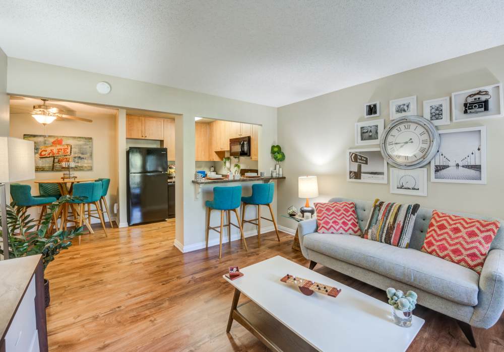 Modern living room with wooden flooring at UCE Apartment Homes in Fullerton, California 