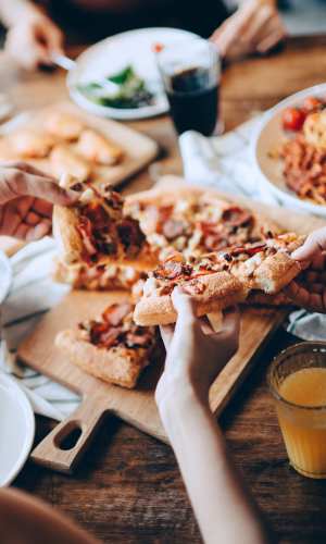 Residents having pizza in a restaurant near Fisher Duplexes in Dallas, Texas