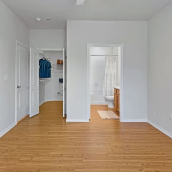 A spacious apartment bedroom with views of the ensuite bathroom/ walk in closet at Cypress Creek Parker Boulevard in Royse City, Texas