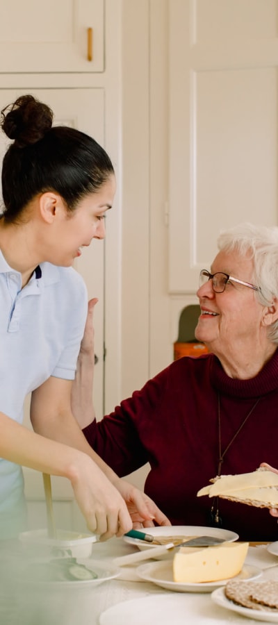 Caretaker assisting a resident with eating in her home at a WISH community