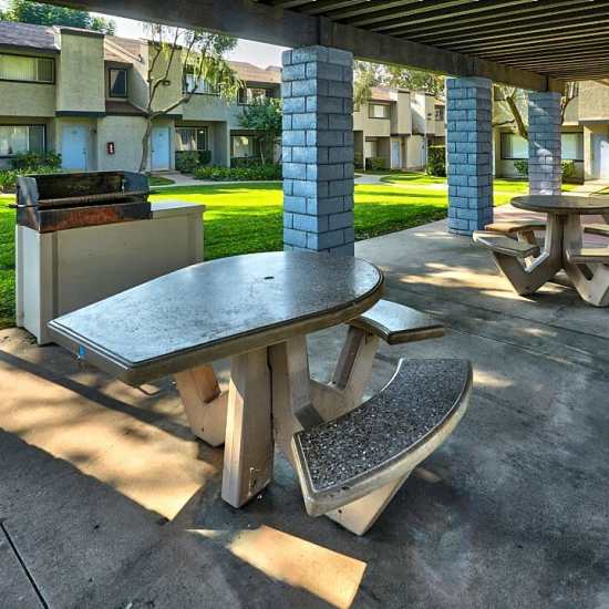 Community sitting area with tables and BBQ grills at Bonita Ranch in Sylmar, California