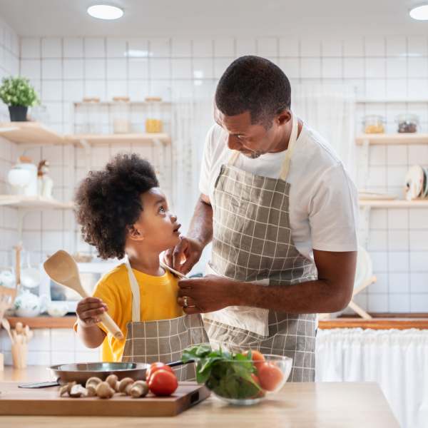 Parent and child cooking together in their apartment at 207 East in Edgewood, Washington