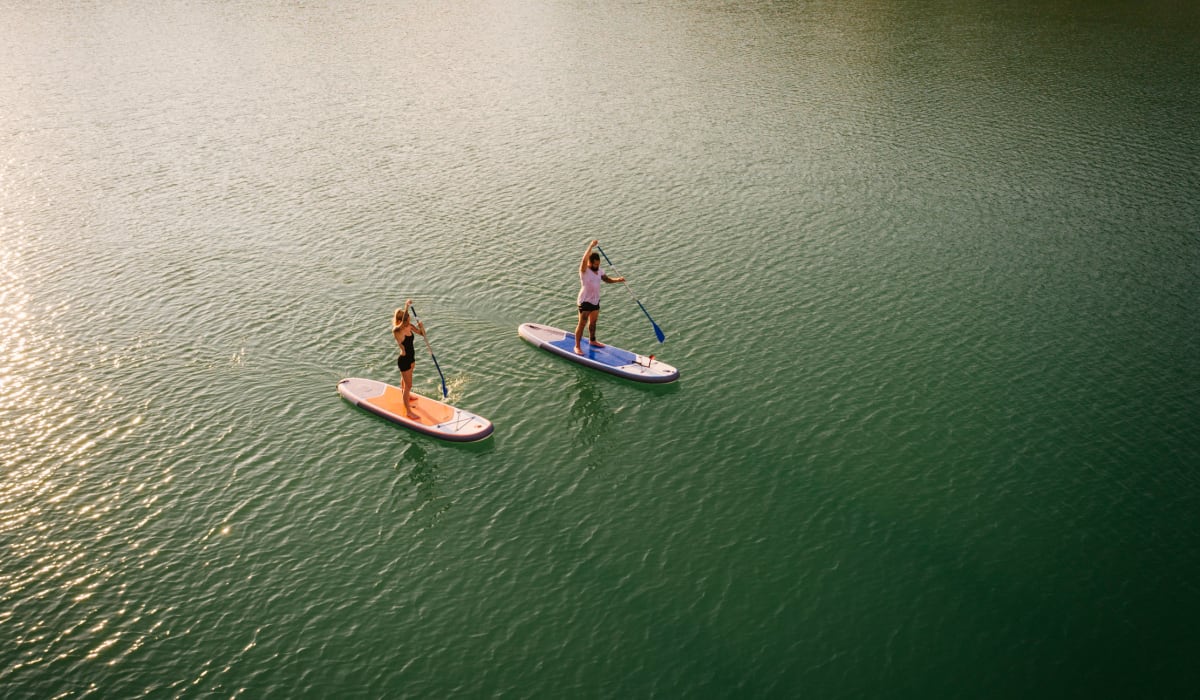 Residents paddle boarding on a lake near The Veridian in Bend, Oregon