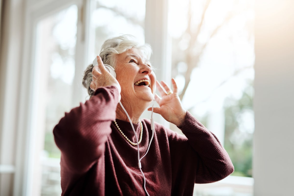 A resident enjoying music through headphones at an Oxford Senior Living location