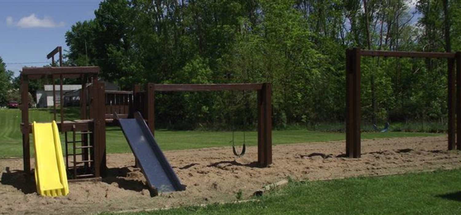 Kids play area with a slide at Mapleview Apartments in Maple Rapids, Michigan