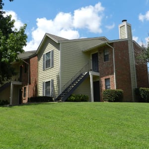 Exterior of apartments and lush green lawn at Pecan Ridge in Midlothian, Texas