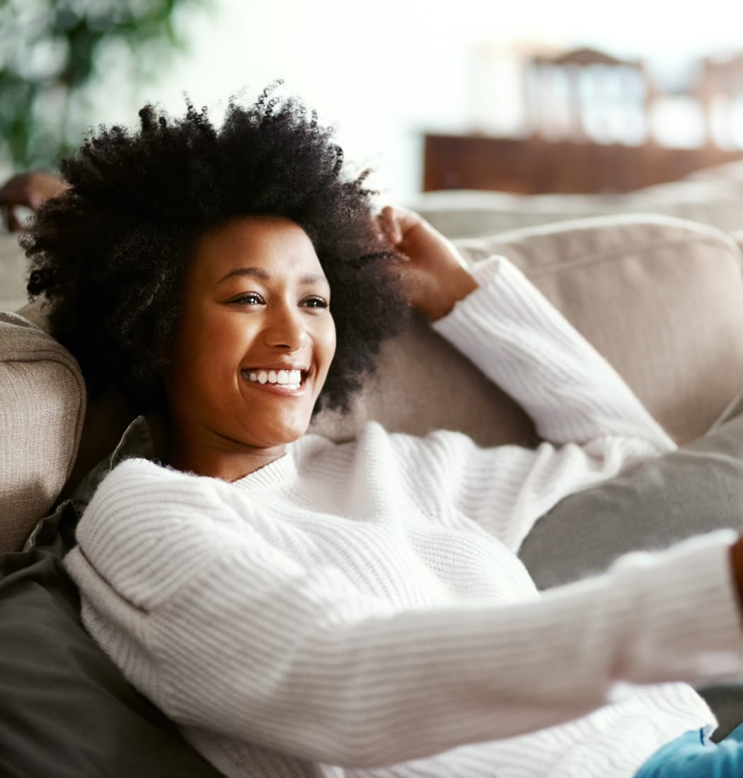 Resident relaxing on her couch at Cedartree Apartments in Santa Clara, California