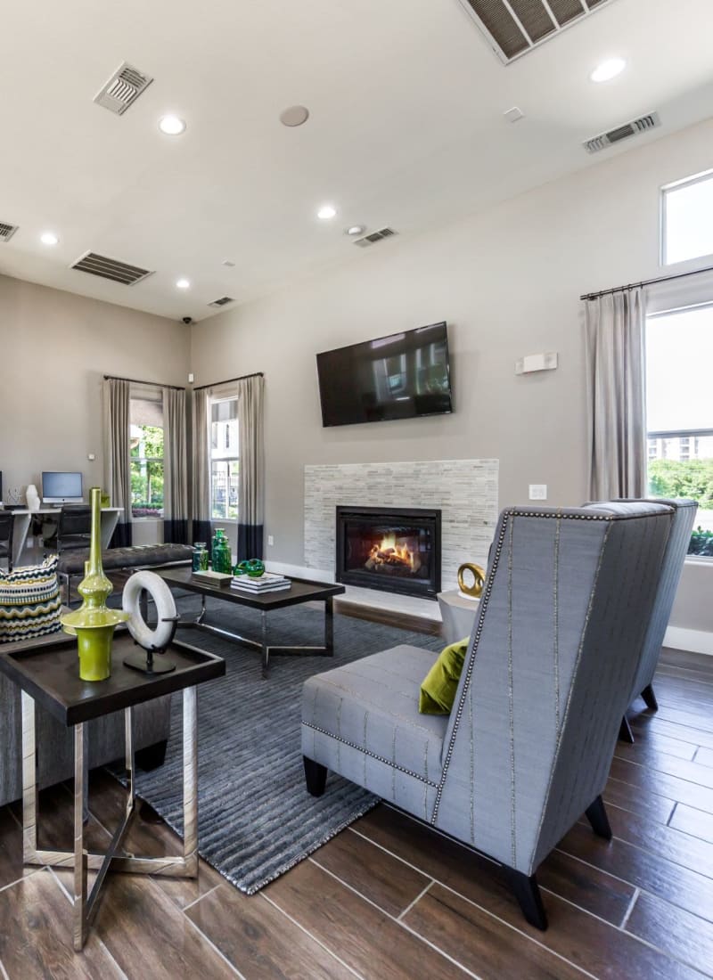 Clubhouse with chairs, a TV, and a fireplace at Marquis at Crown Ridge in San Antonio, Texas