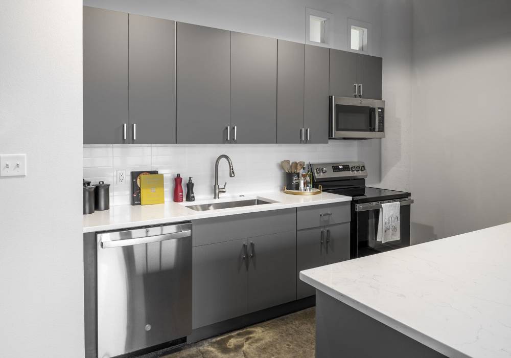 Modern kitchen with stainless steel appliances at American Can Apartments in New Orleans, Louisiana 