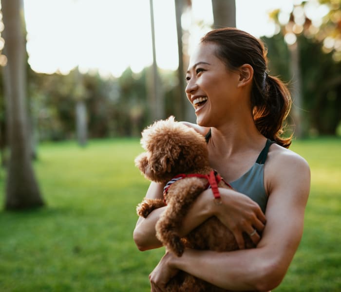 Resident holding her dog at Enclave at Grapevine's dog park in Grapevine, Texas