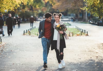 Resident couple strolling with some freshly bought flowers after doing some shopping downtown near Santana Ridge in Denver, Colorado