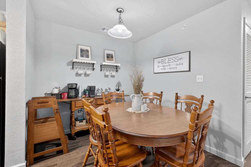 Charming dining area with a rustic wooden table and warm decor at Lakewood Crossing in Granbury, Texas.
