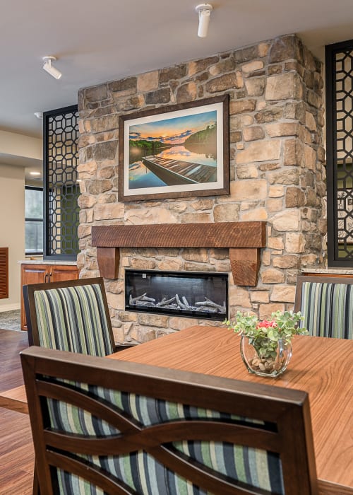 Resident dining area with stone fireplace at The Pillars of Hermantown in Hermantown, Minnesota