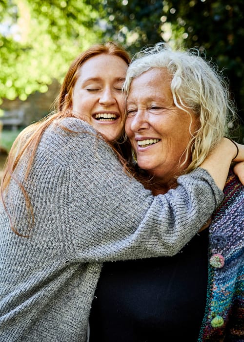 Granddaughter hugging her grandmother outside Grand Villa of Delray West in Delray Beach, Florida