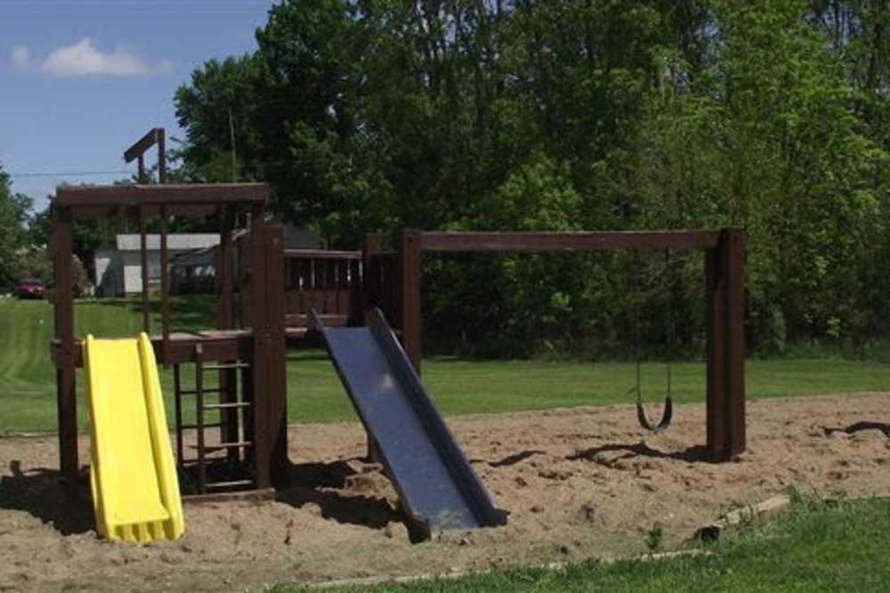 Kids play area with a slide, swing at Mapleview Apartments in Maple Rapids, Michigan