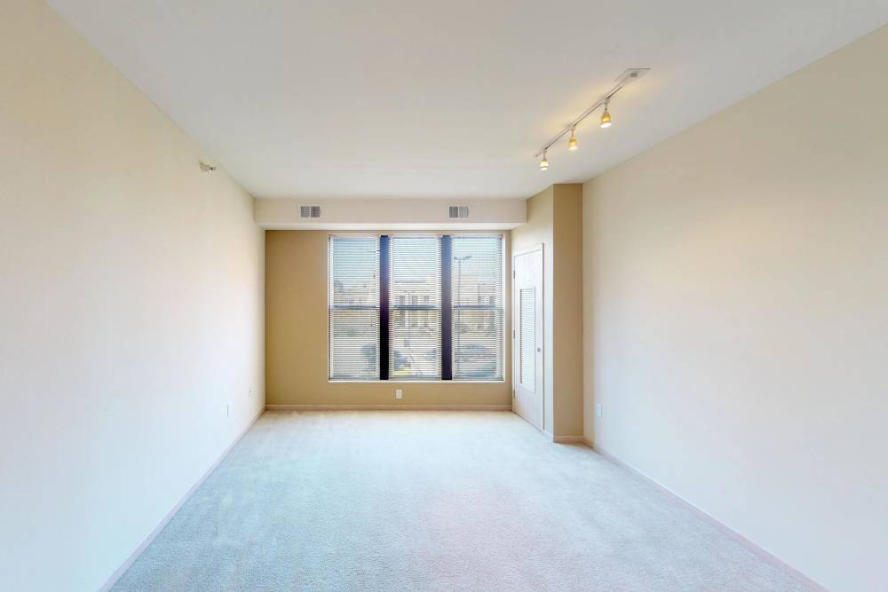 Spacious living area with large window and carpeted floor at Vine Street Lofts in Des Moines, Iowa